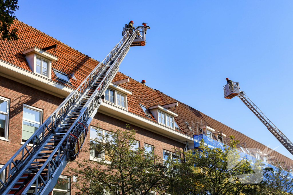 Zwarte rookwolken bij grote brand op dak van woning