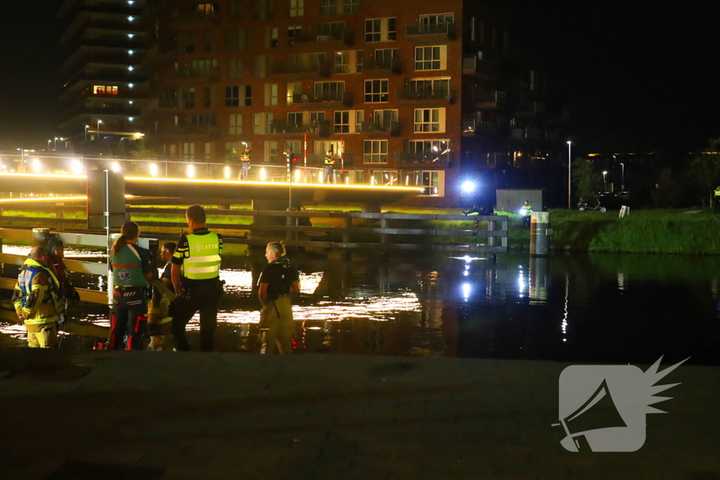 Persoon klimt op palen onder brug en word gebeten door politiehond