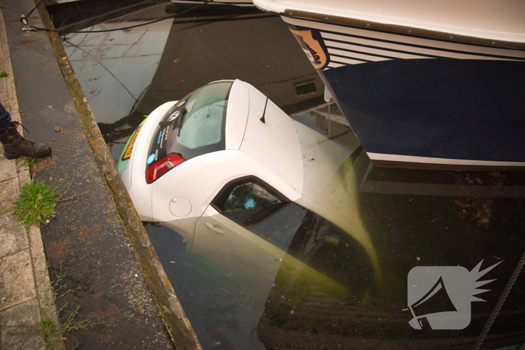 Auto rolt jachthaven in en gaat kopje onder