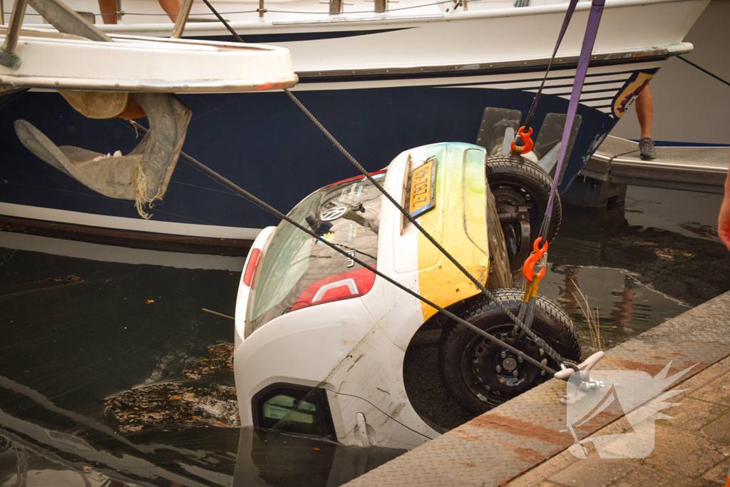 Auto rolt jachthaven in en gaat kopje onder