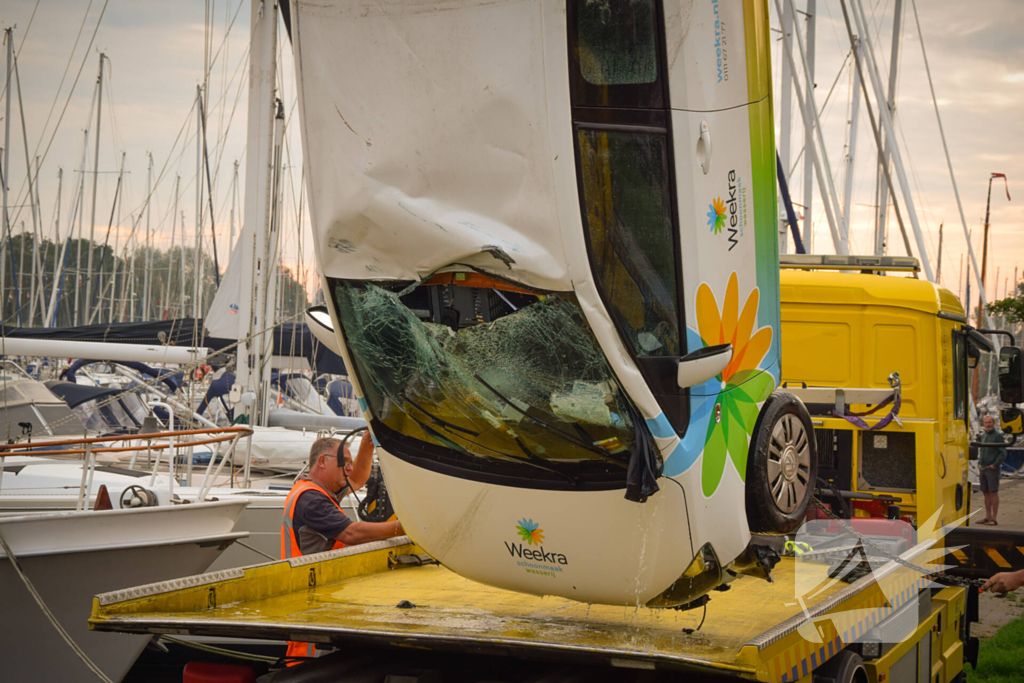 Auto rolt jachthaven in en gaat kopje onder