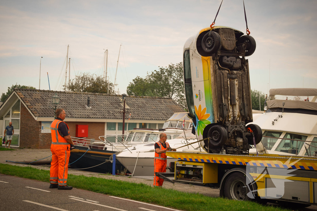 Auto rolt jachthaven in en gaat kopje onder