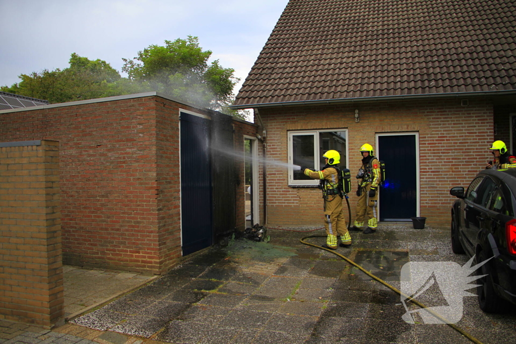 Brand in kliko slaat over op garagedeur