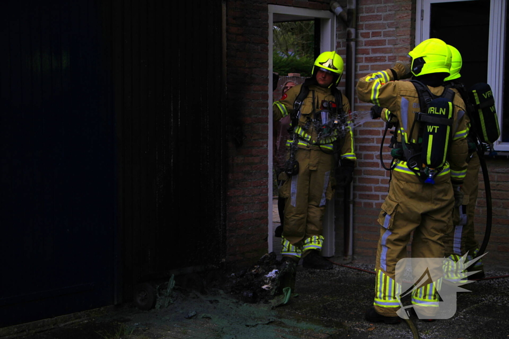 Brand in kliko slaat over op garagedeur