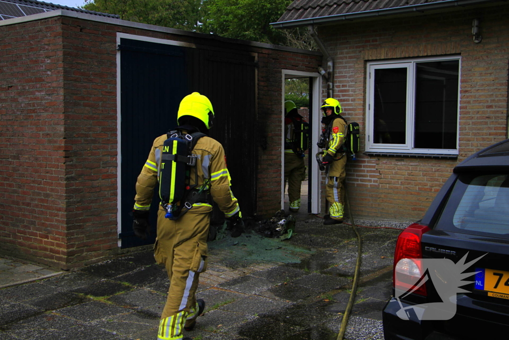 Brand in kliko slaat over op garagedeur