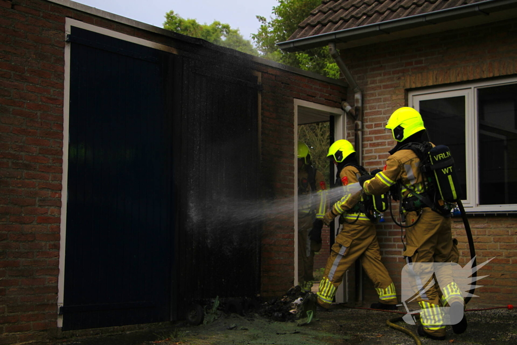 Brand in kliko slaat over op garagedeur