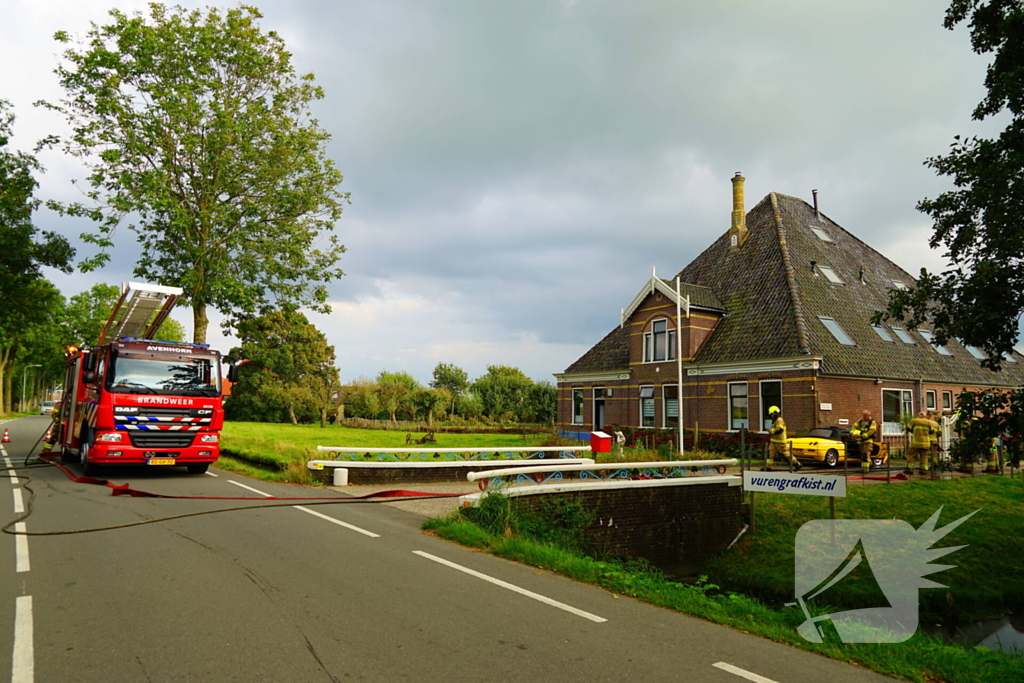 Personenwagen naast woning vliegt in brand