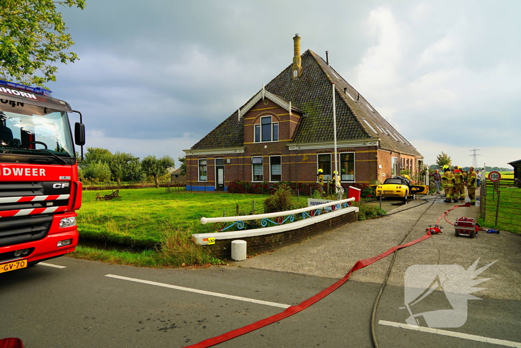 Personenwagen naast woning vliegt in brand