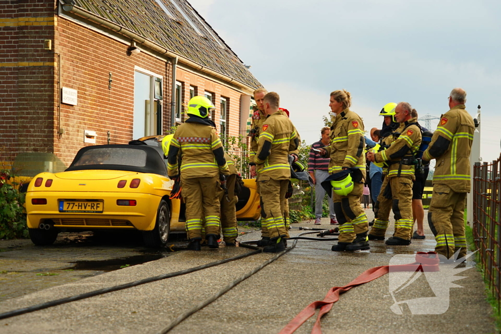 Personenwagen naast woning vliegt in brand