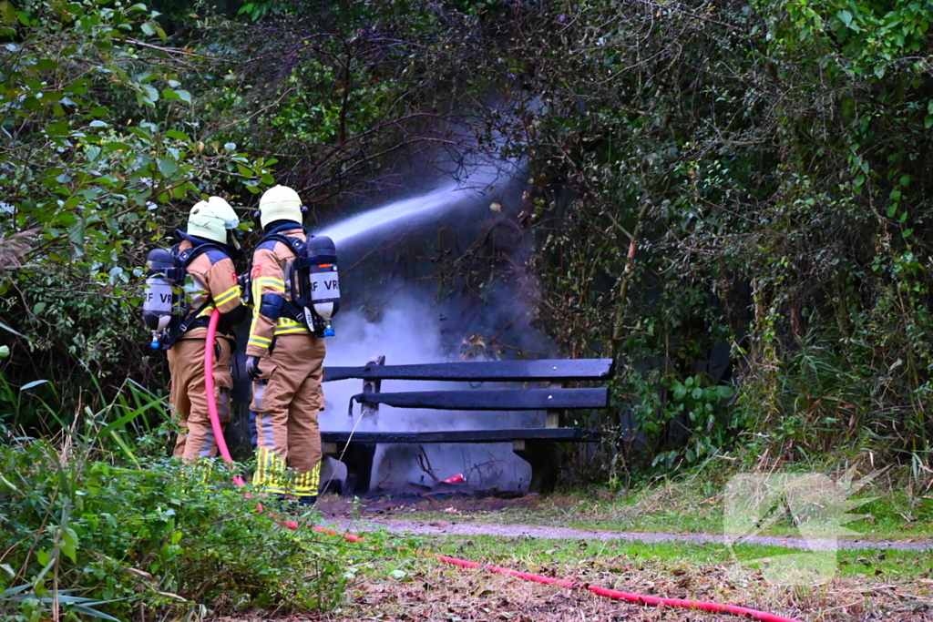 Brandweer blust brandende houten bank