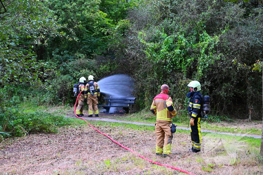 Brandweer blust brandende houten bank