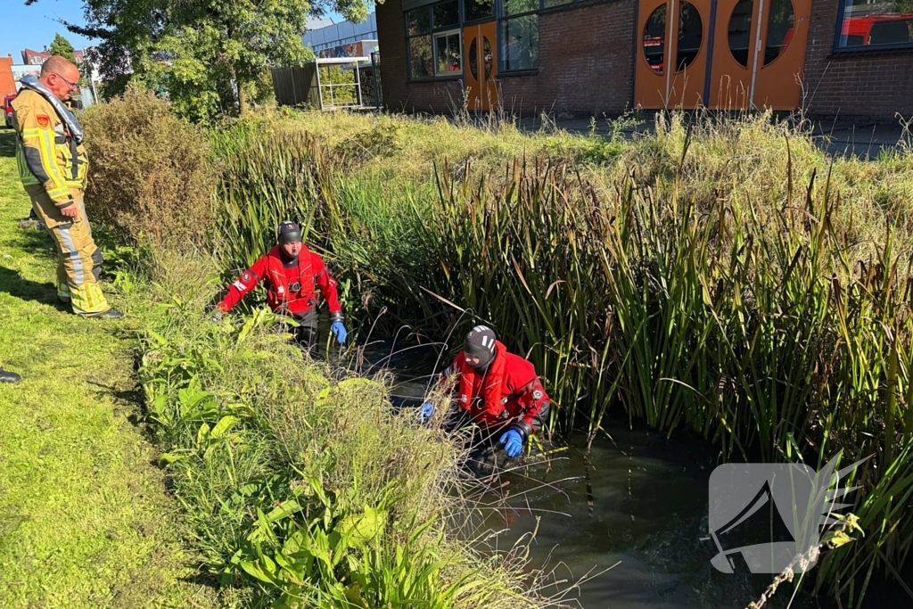 Brandweer doorzoekt sloot na aantreffen kleding langs waterkant