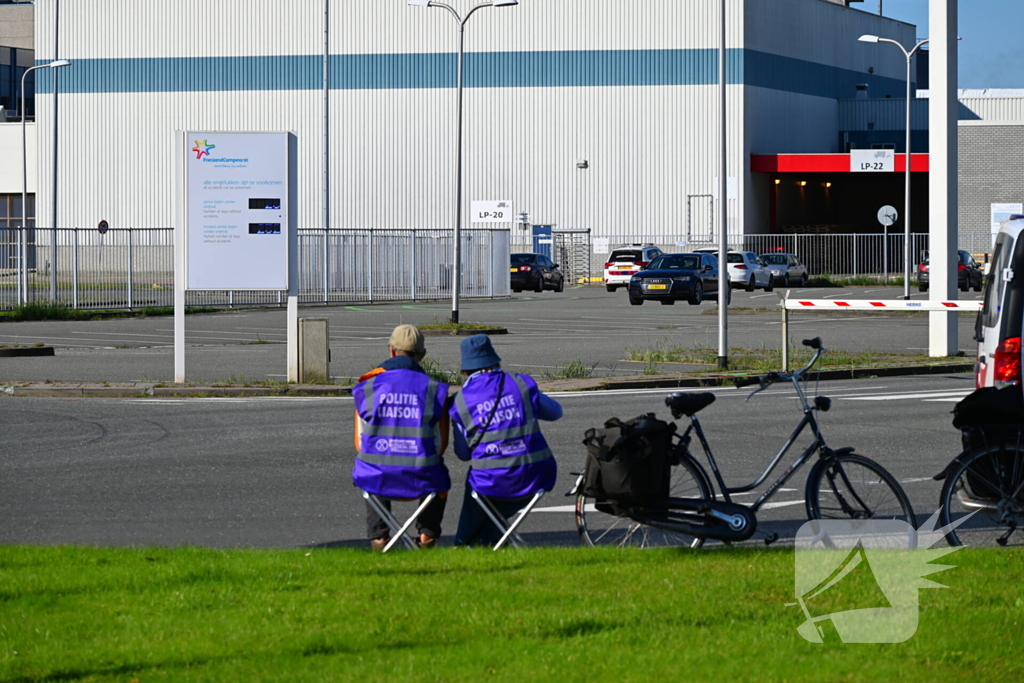 Demonstranten klimmen over hekken van zuivel fabrikant