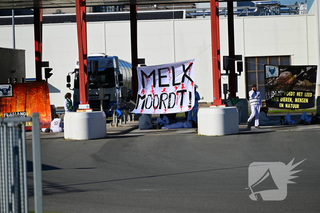 Demonstranten klimmen over hekken van zuivel fabrikant