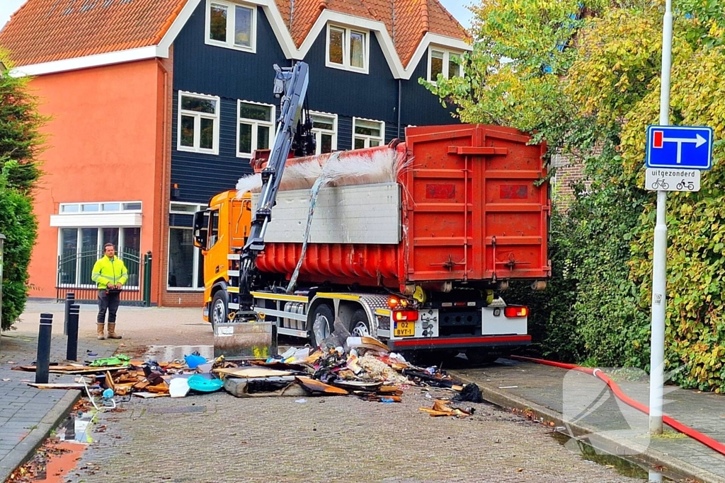 Containerwagen dumpt brandend afval op straat