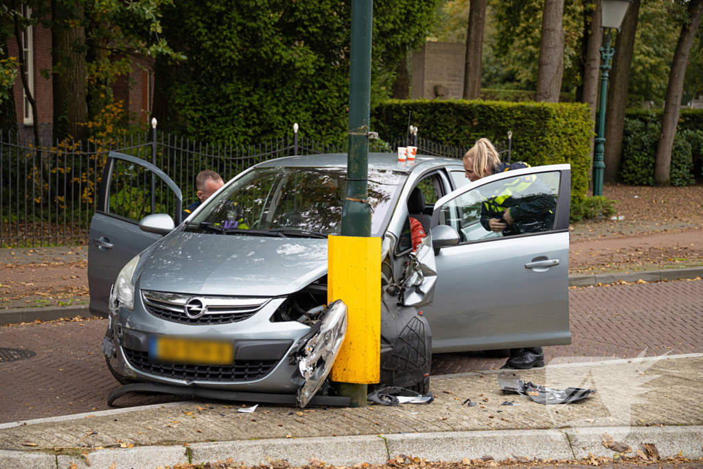 Automobilist ramt verkeersbord en lantaarnpaal