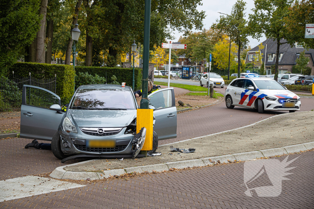 Automobilist ramt verkeersbord en lantaarnpaal