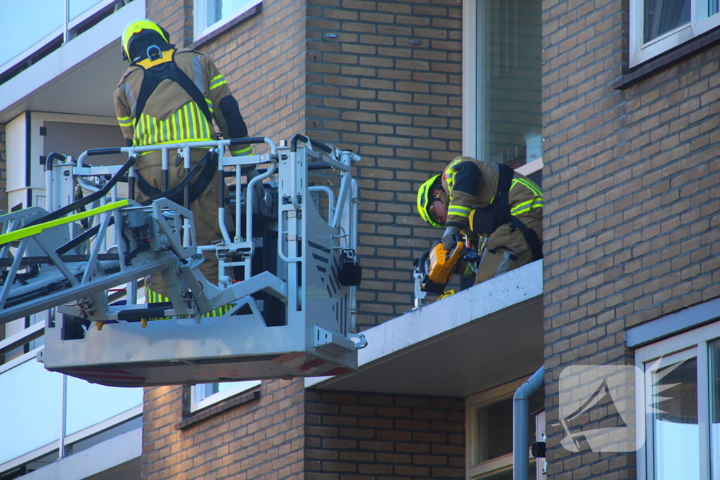 Persoon door hijskraan uit flatwoning getakeld