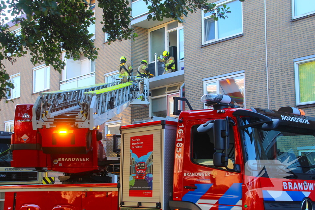 Persoon door hijskraan uit flatwoning getakeld