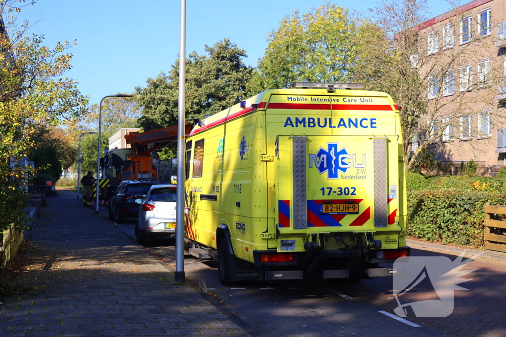 Persoon door hijskraan uit flatwoning getakeld