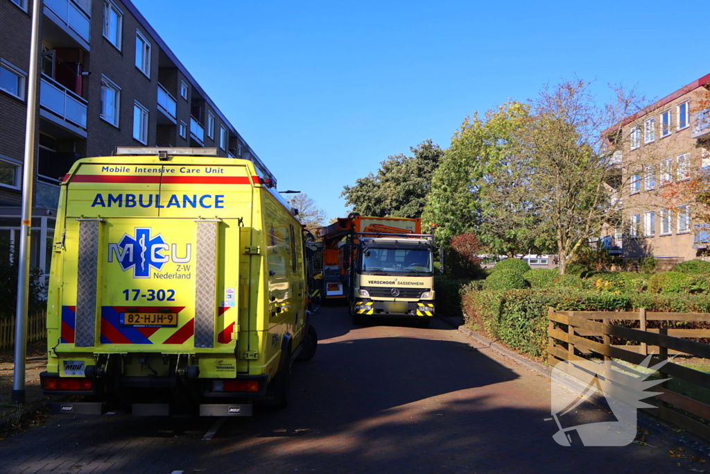 Persoon door hijskraan uit flatwoning getakeld