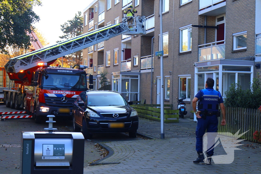 Persoon door hijskraan uit flatwoning getakeld