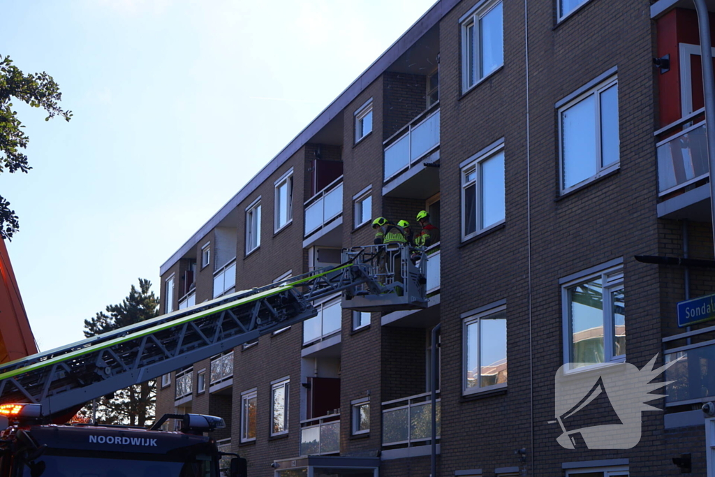 Persoon door hijskraan uit flatwoning getakeld