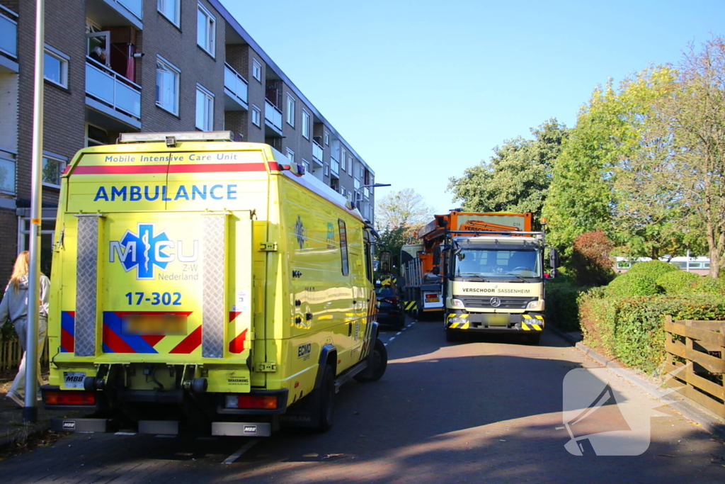 Persoon door hijskraan uit flatwoning getakeld