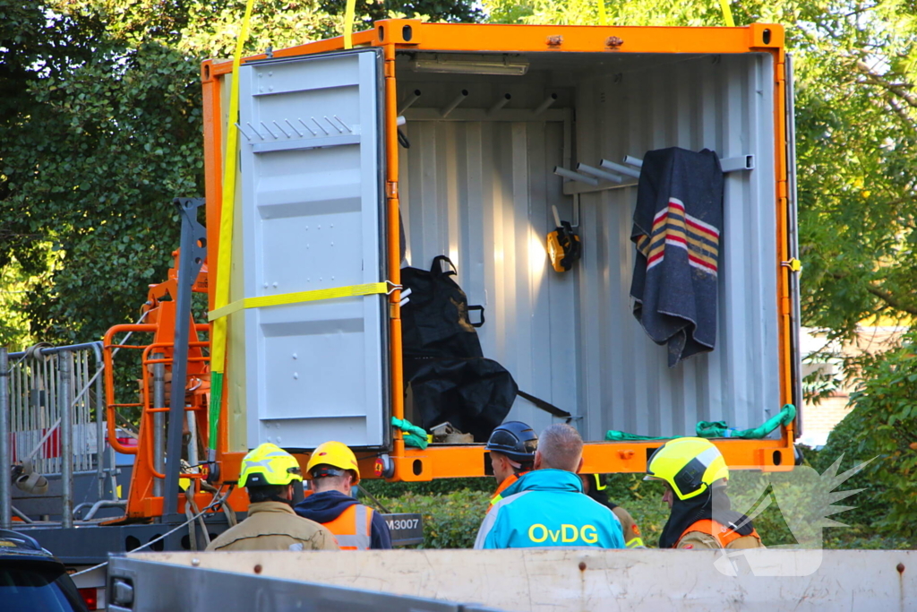 Persoon door hijskraan uit flatwoning getakeld