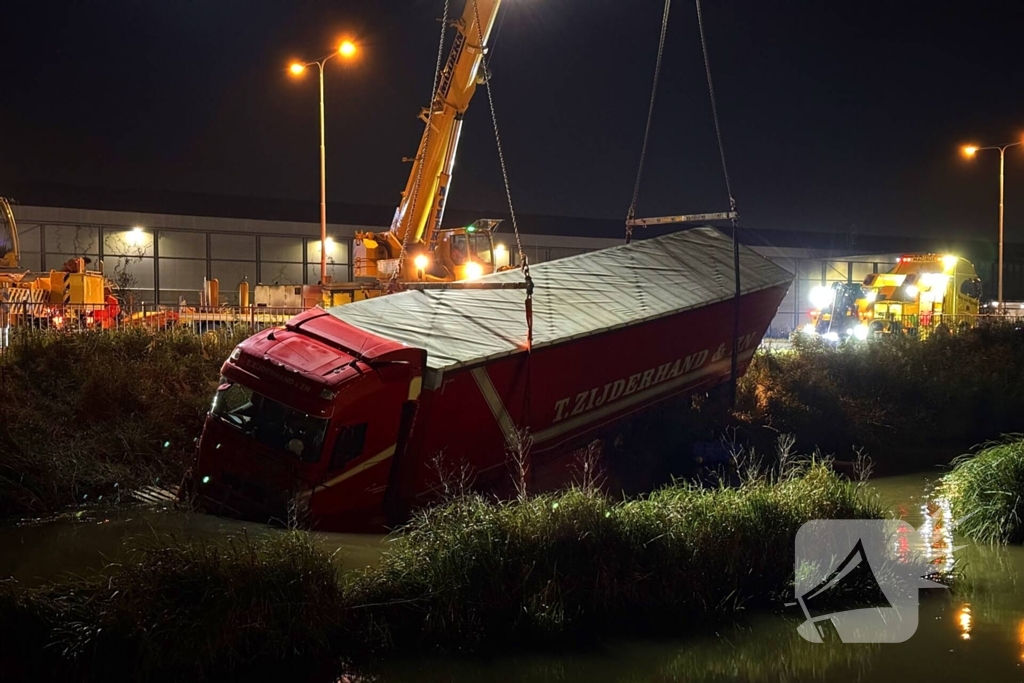 Te water geraakte vrachtwagen geborgen door grote hijskranen