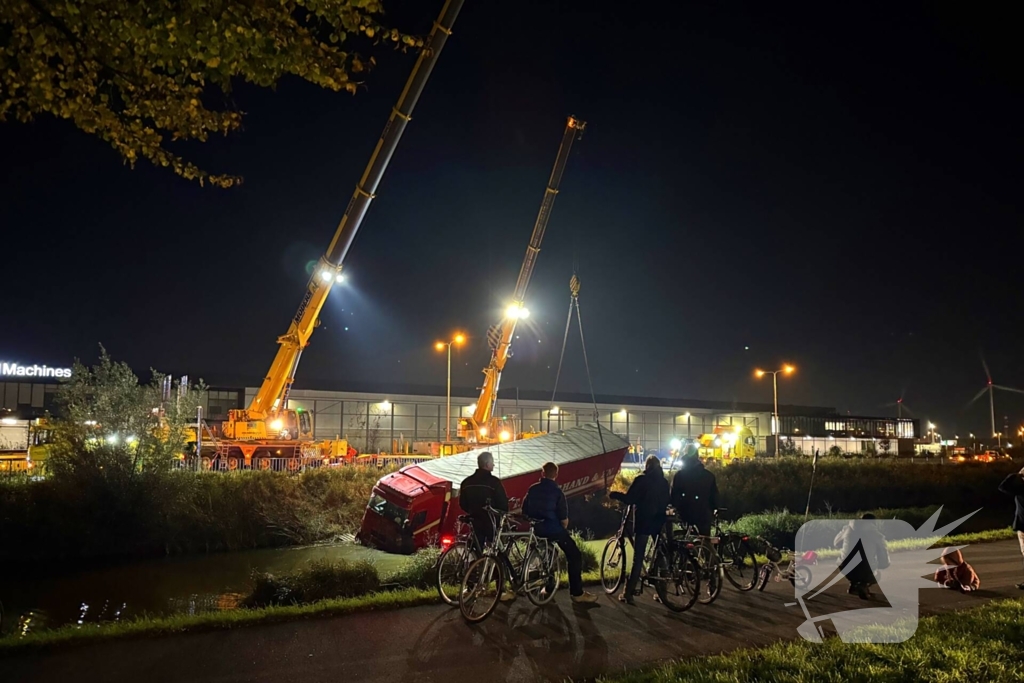 Te water geraakte vrachtwagen geborgen door grote hijskranen