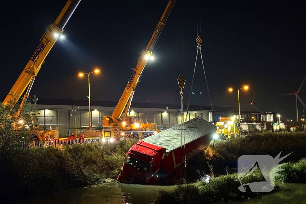 Te water geraakte vrachtwagen geborgen door grote hijskranen