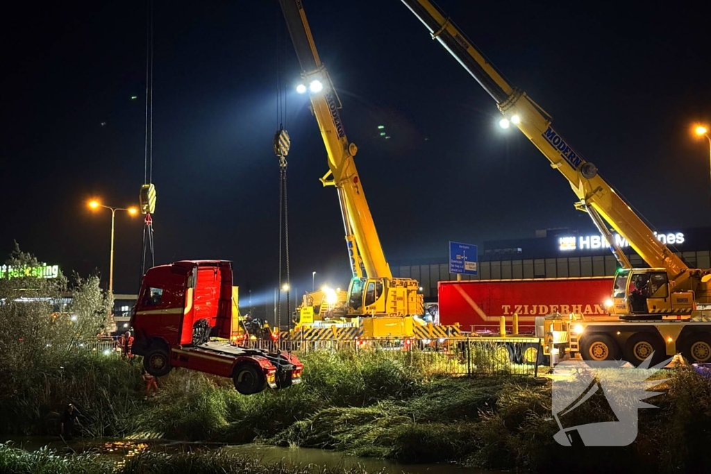 Te water geraakte vrachtwagen geborgen door grote hijskranen