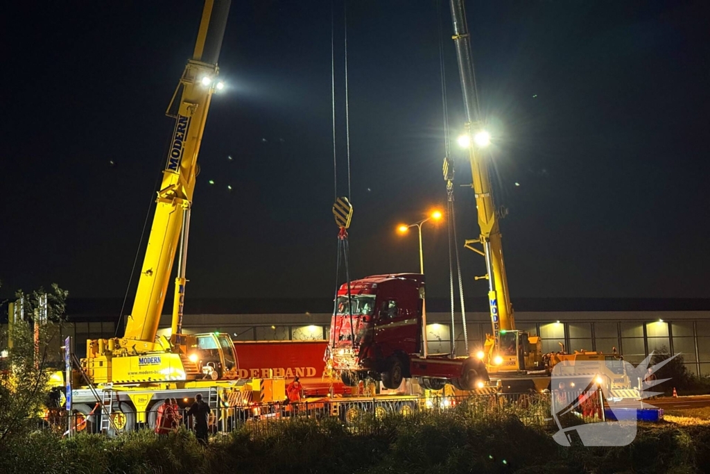 Te water geraakte vrachtwagen geborgen door grote hijskranen