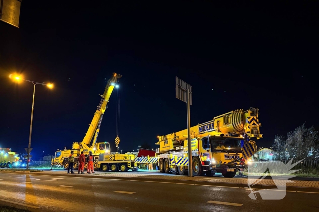 Te water geraakte vrachtwagen geborgen door grote hijskranen