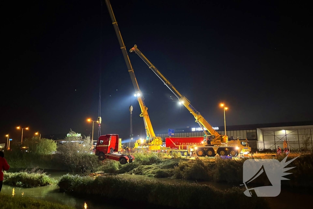 Te water geraakte vrachtwagen geborgen door grote hijskranen