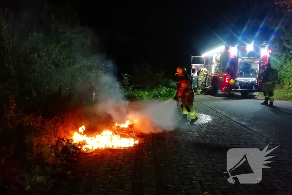 Brandweer dooft in brand gestoken afval