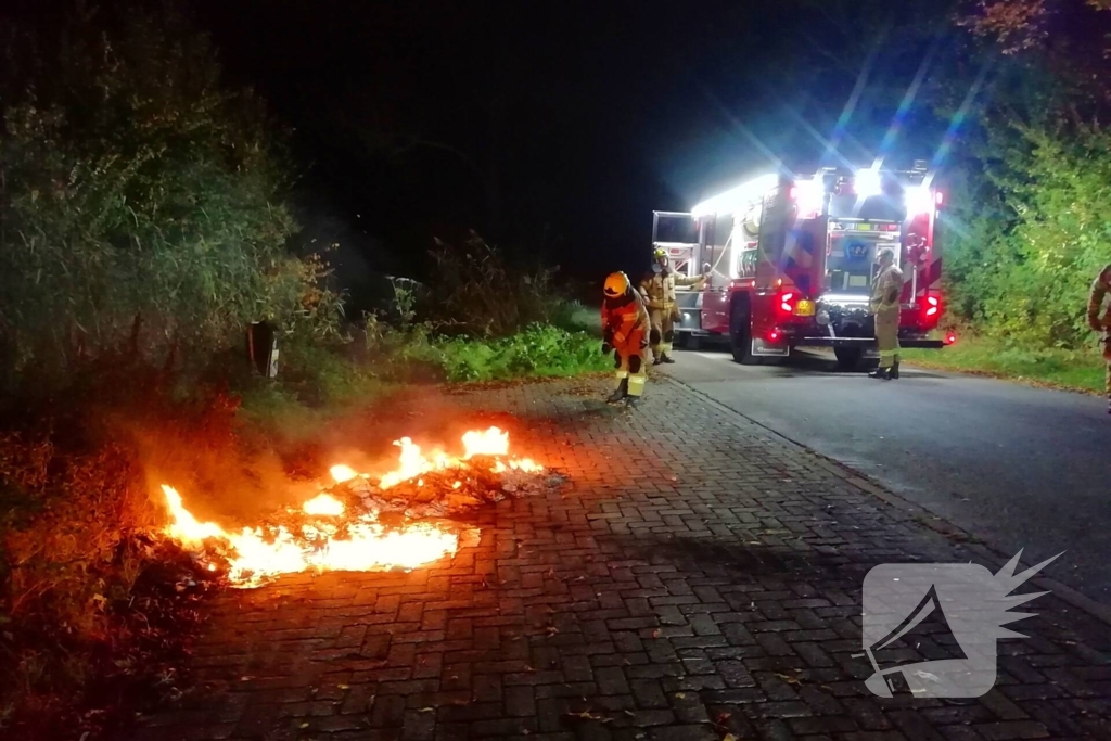 Brandweer dooft in brand gestoken afval