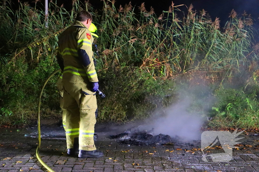 Brandweer dooft in brand gestoken afval