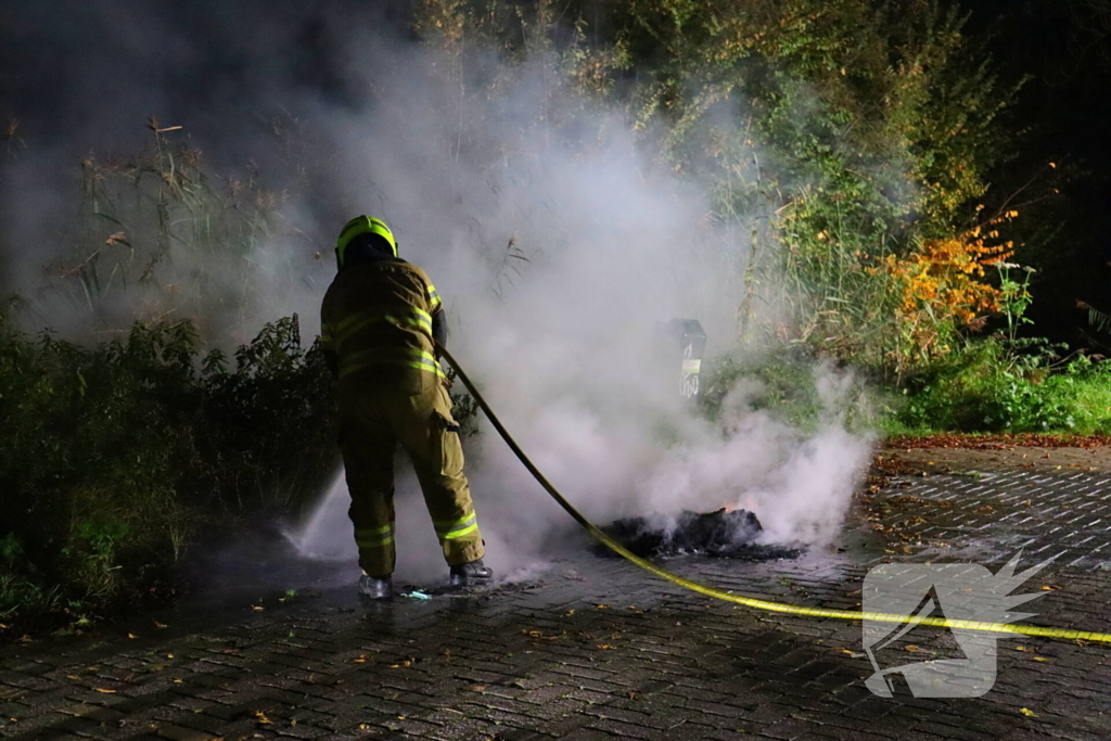 Brandweer dooft in brand gestoken afval