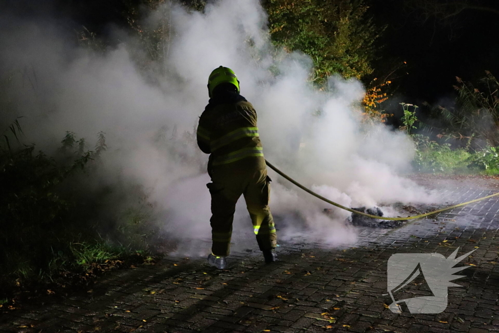 Brandweer dooft in brand gestoken afval