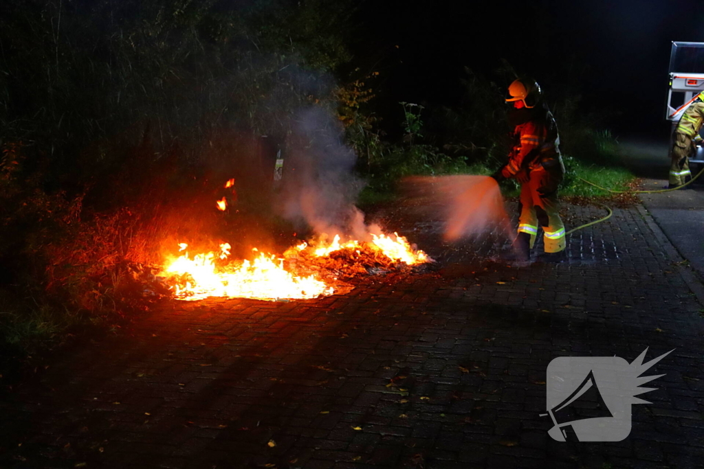 Brandweer dooft in brand gestoken afval