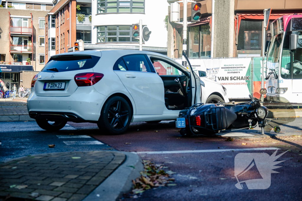 Scooter rijdt in zijkant van auto