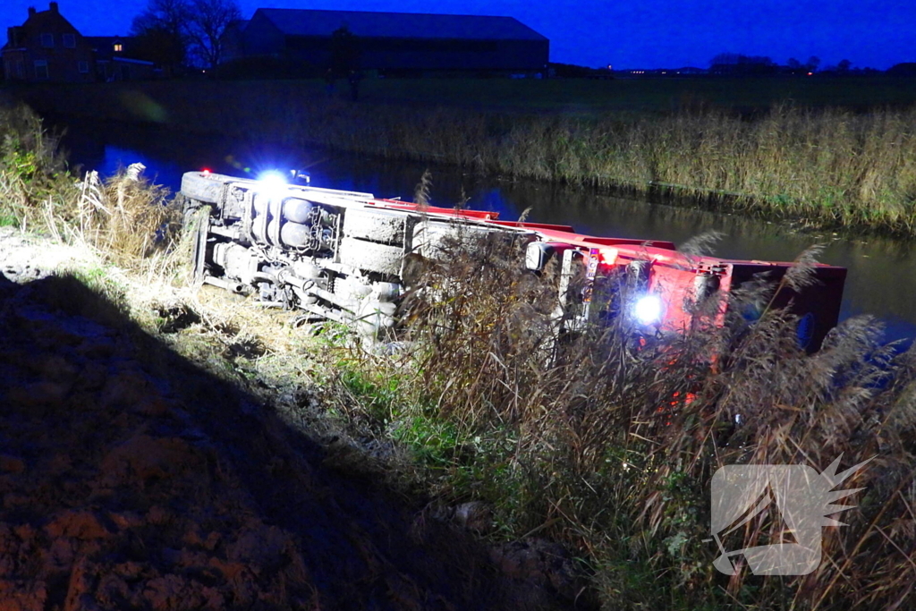 Vrachtwagen op zijn kant in de sloot