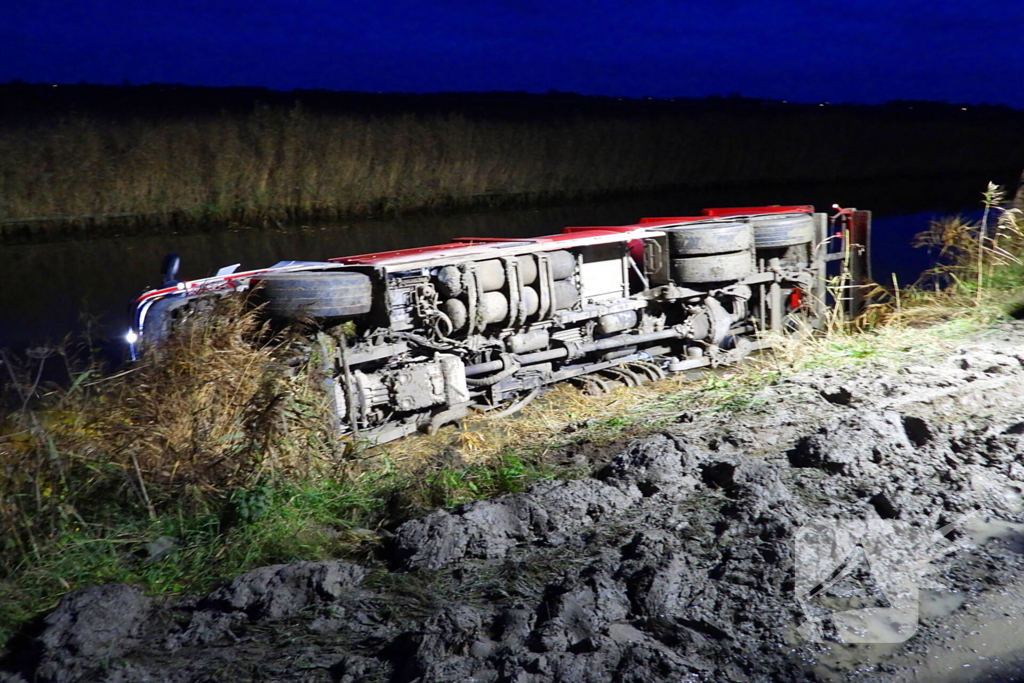 Vrachtwagen op zijn kant in de sloot