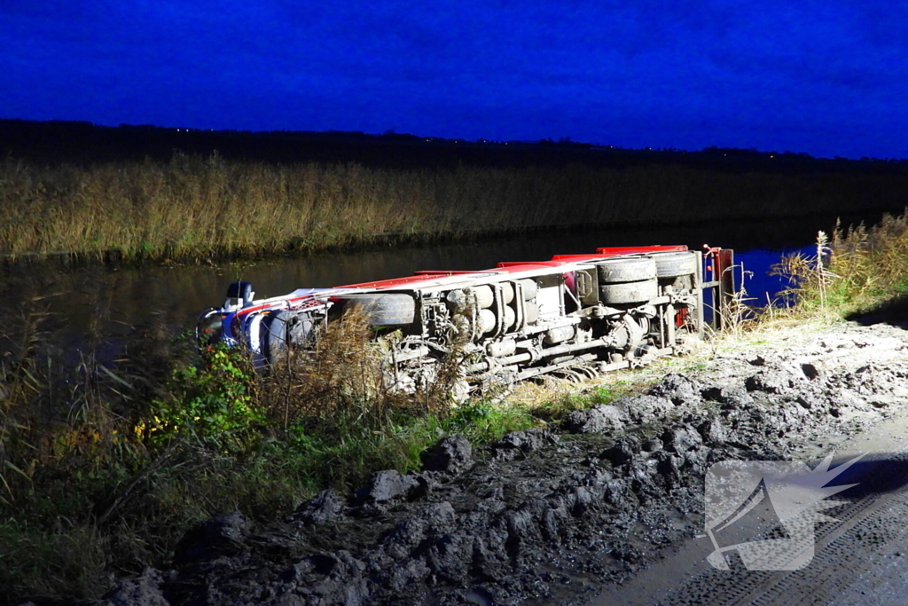 Vrachtwagen op zijn kant in de sloot