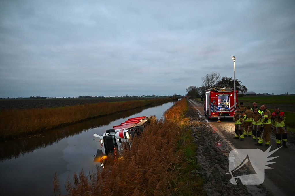 Vrachtwagen op zijn kant in de sloot