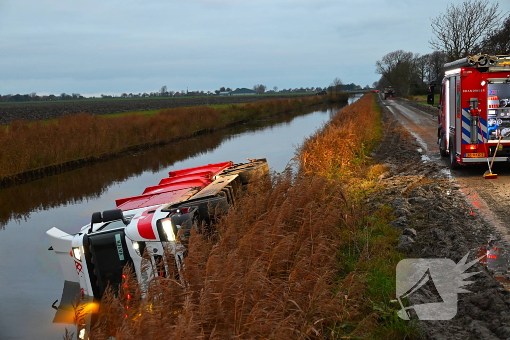 Vrachtwagen op zijn kant in de sloot