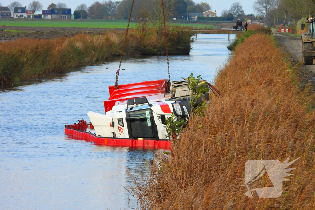 Vrachtwagen op zijn kant in de sloot