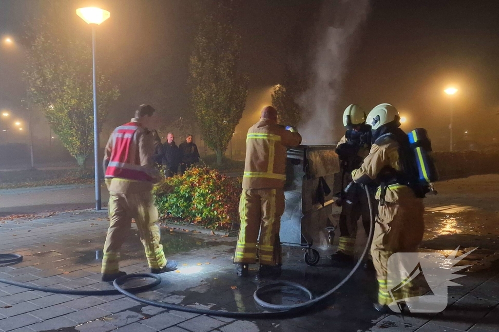 Brandweer blust brand in afvalcontainer